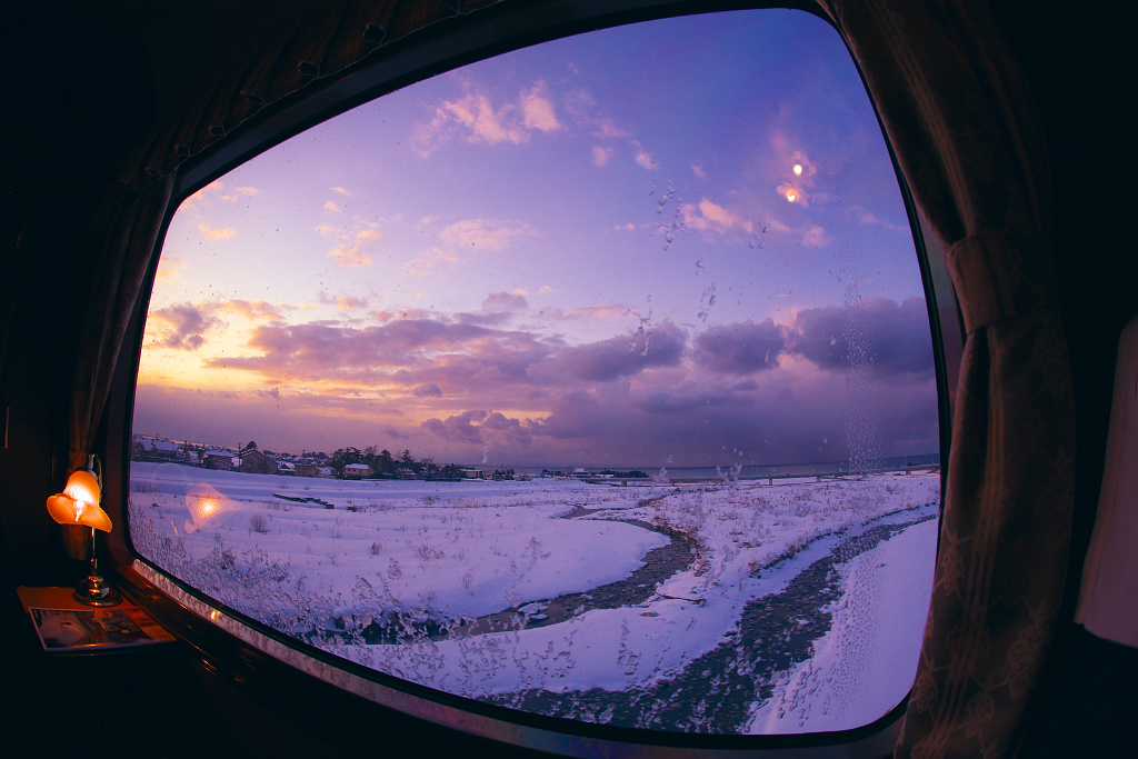 凍り付いた車窓から眺める冬の日本海側の景色